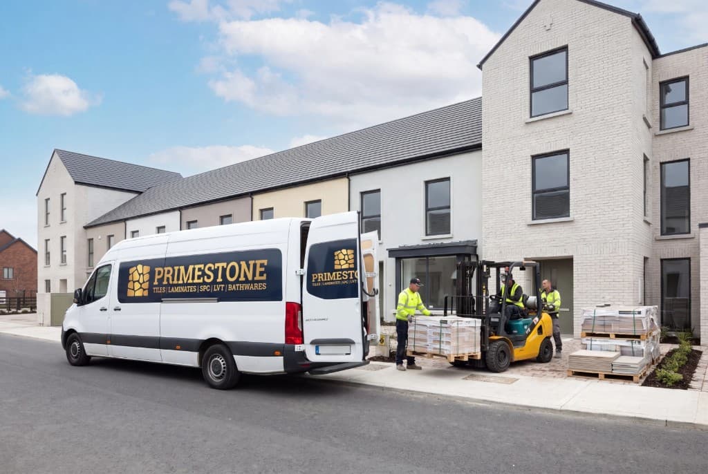 Primestone delivery van and forklift unloading pallets of tiles at a new housing development